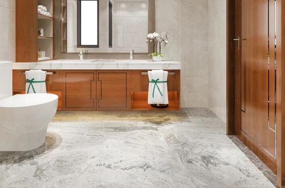 Modern bathroom with wooden cabinetry, marble floor, white toilet, and green-accented towels.