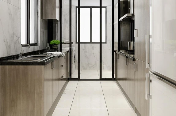 Modern kitchen with sleek cabinetry, black countertops, and a glass partition to a bright space.