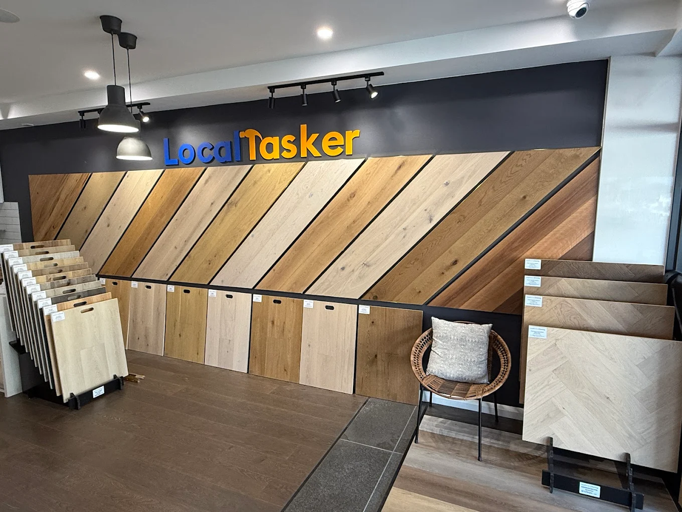 Exterior of Local Tasker store with signage showing wholesale SPC carpets, tiles, and timber.